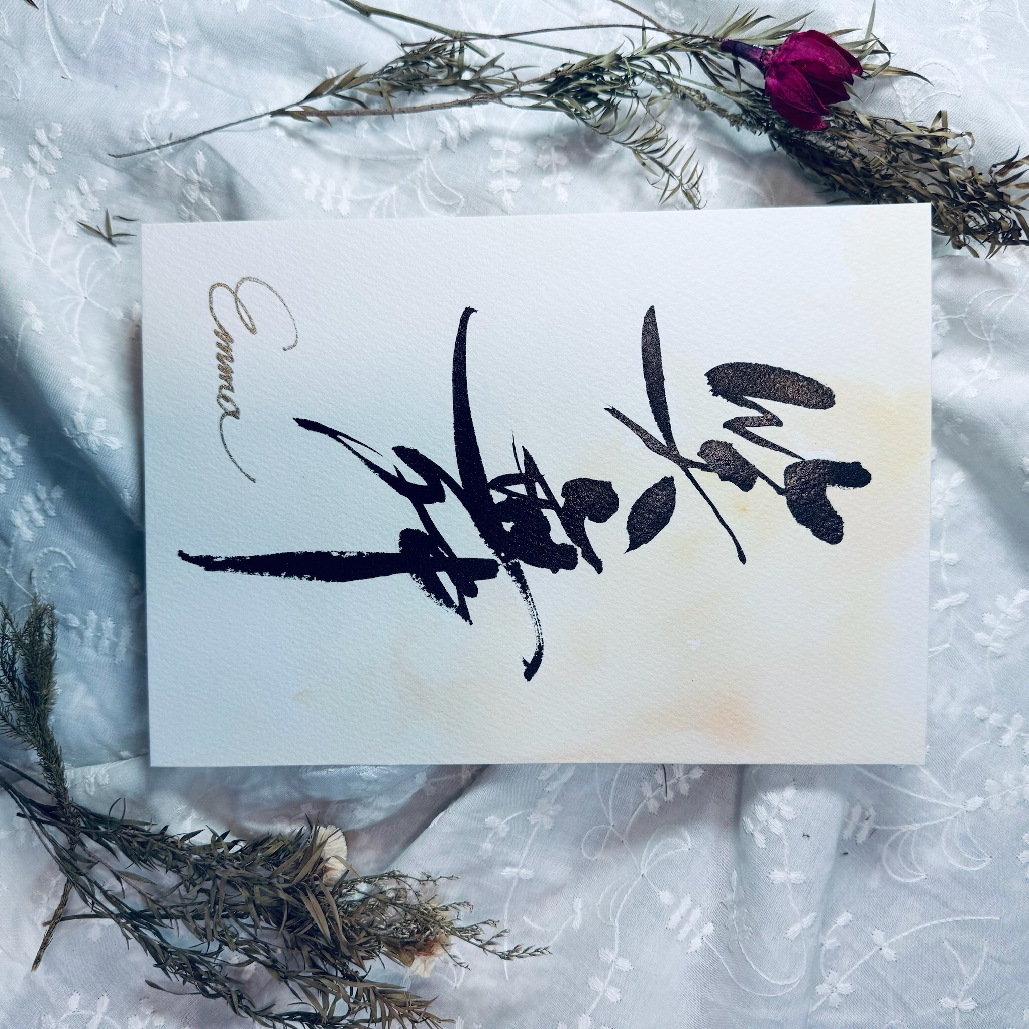 花とともに撮影された命名書『笑舞』のカード作品